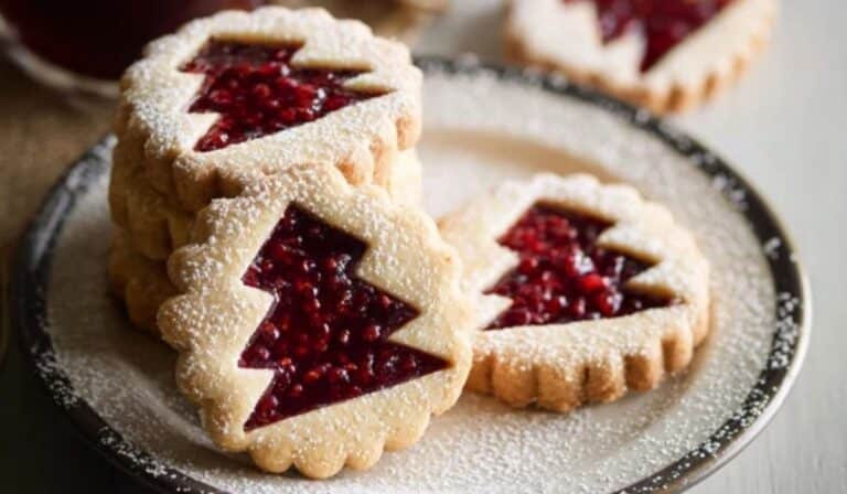 Raspberry Linzer Cookies stacked with jam filling and powdered sugar