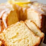 Iced Lemon Pound Cake sliced on a wooden stand
