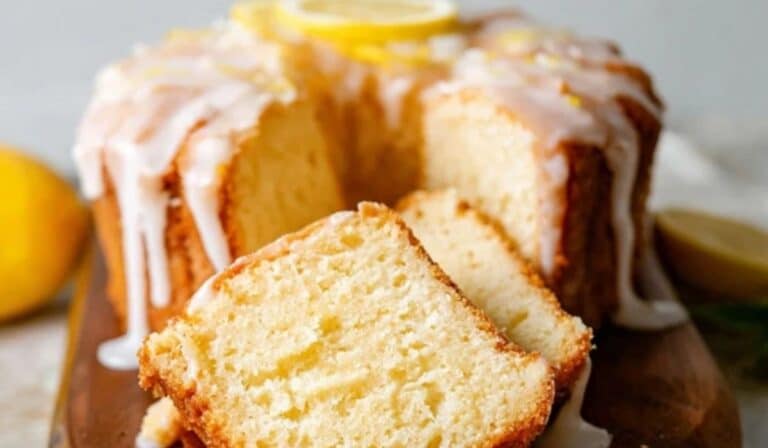 Iced Lemon Pound Cake sliced on a wooden stand