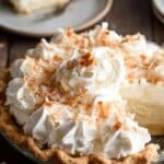 Coconut Cream Pie slice with whipped cream and toasted coconut