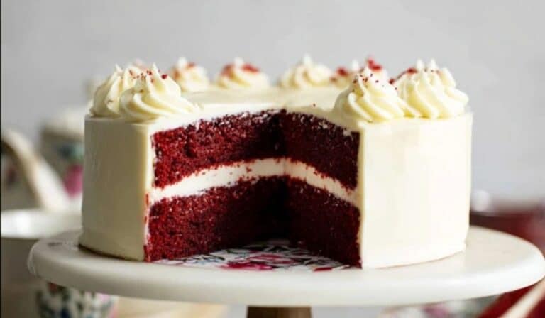 Red Velvet Cake on cake stand with cream cheese frosting